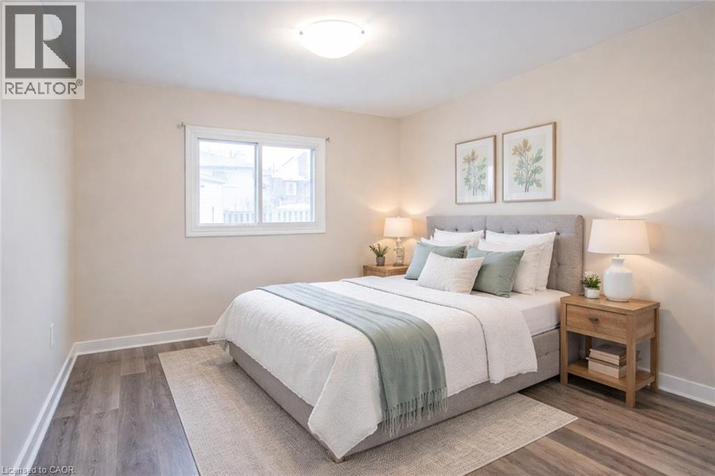 A bedroom with a bed, nightstand, and two framed pictures on the wall.