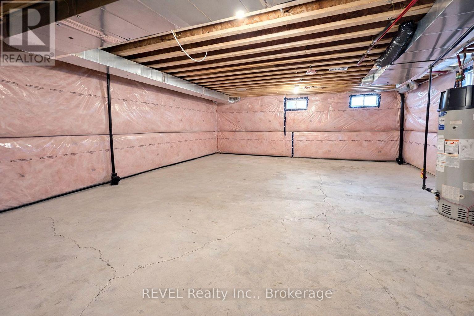 A spacious unfinished basement with a concrete floor and exposed ceiling beams.