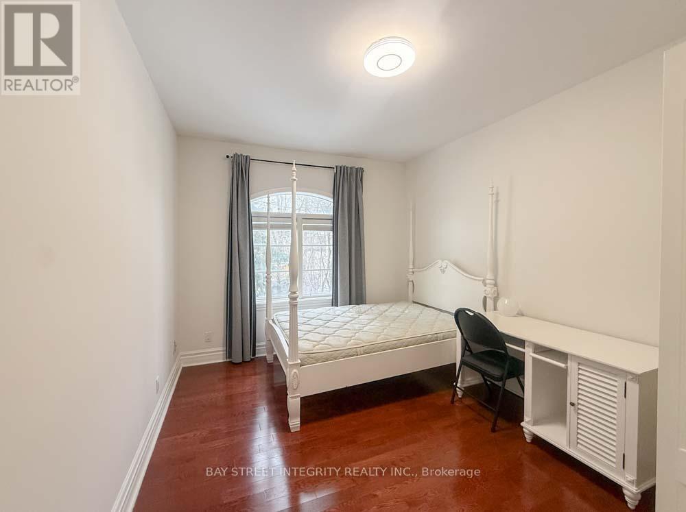 A bedroom with a bed, chair, and window.