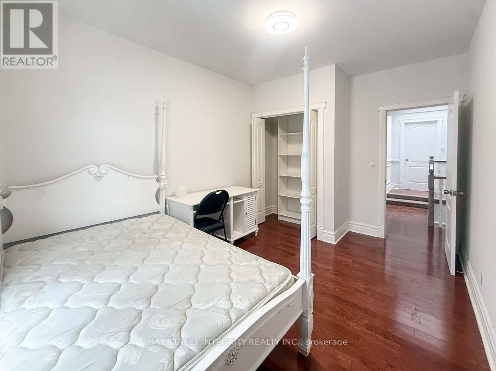 A bedroom with a large bed and a desk with a chair.