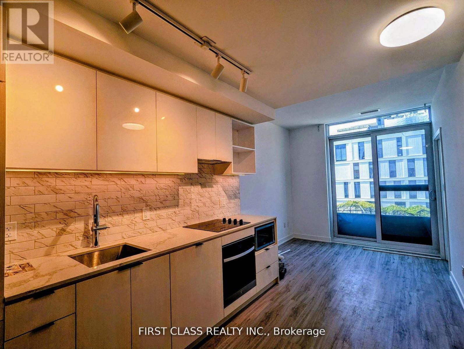 A kitchen with a marble backsplash and stainless steel appliances.