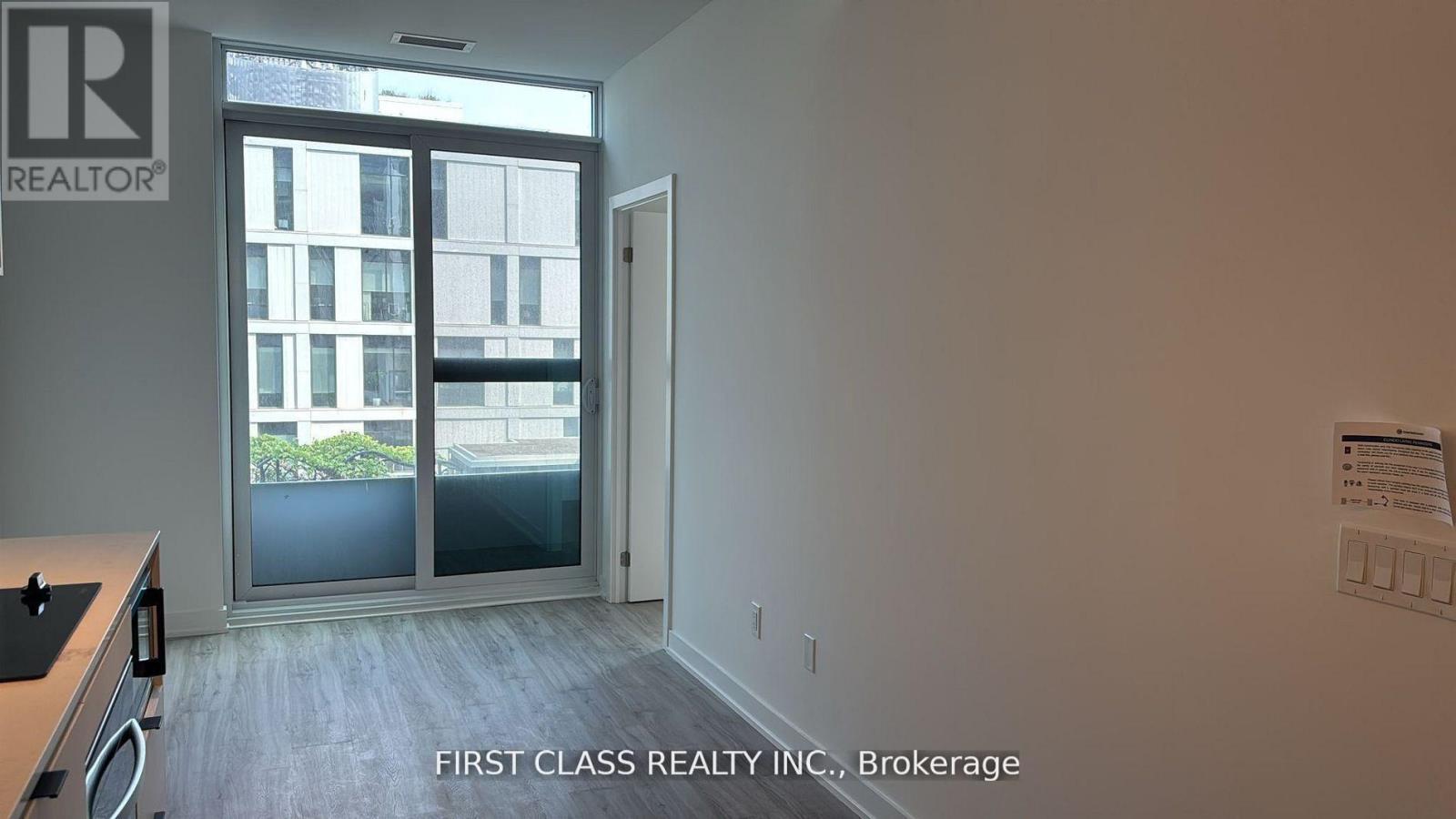 A room with a window showing a view of a building outside.