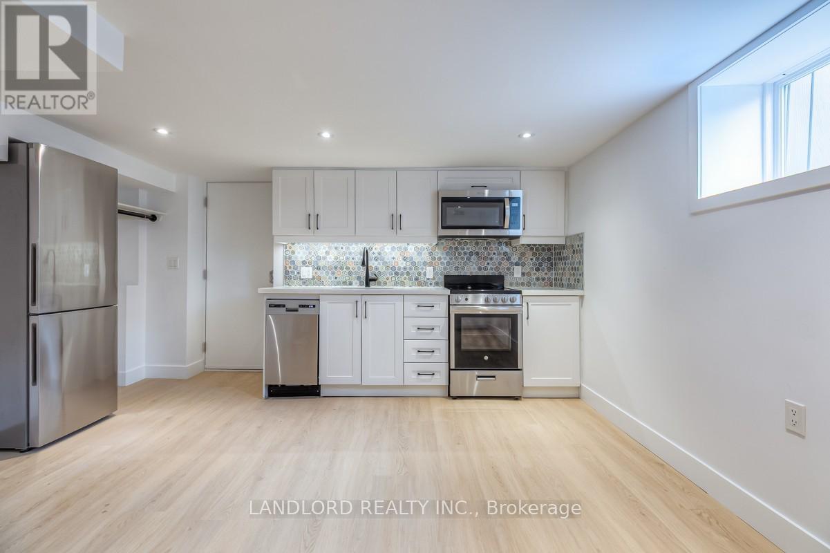 A kitchen with white cabinets and a stainless steel refrigerator.