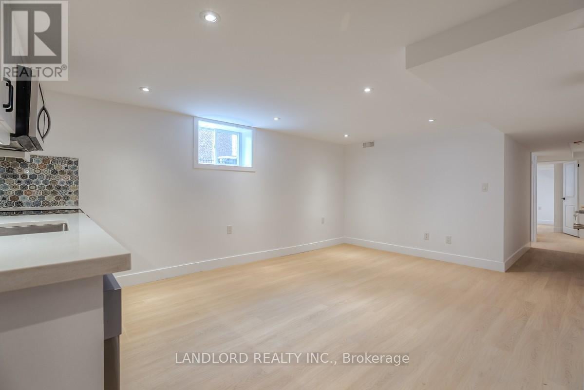 A spacious room with wooden flooring and a window.
