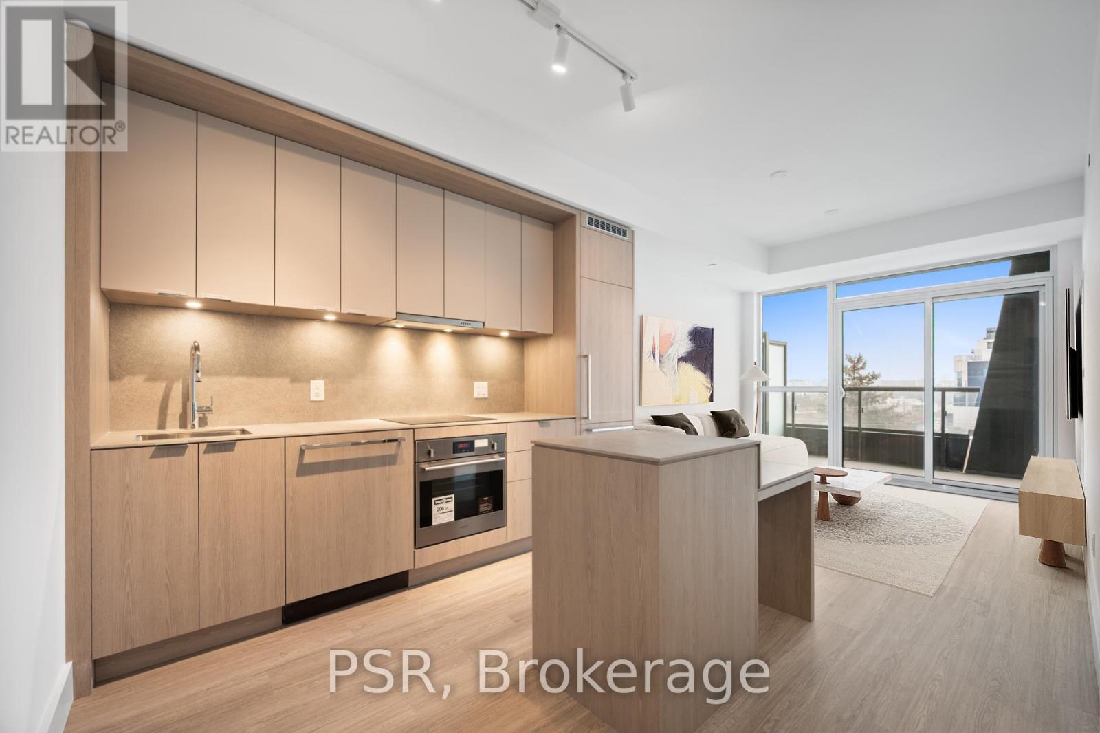 A modern kitchen with wooden cabinets and a large window.