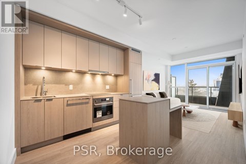 A modern kitchen with wooden cabinets and a large window.