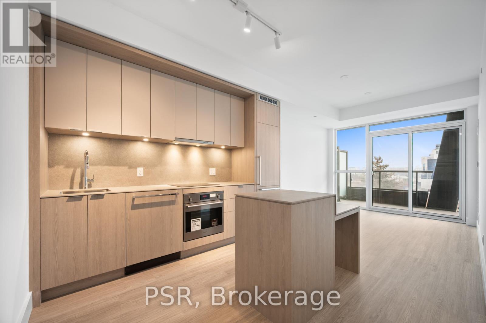A modern kitchen with wooden cabinets and a large window.