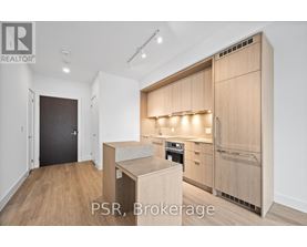 A modern kitchen with wooden cabinets and a black door.