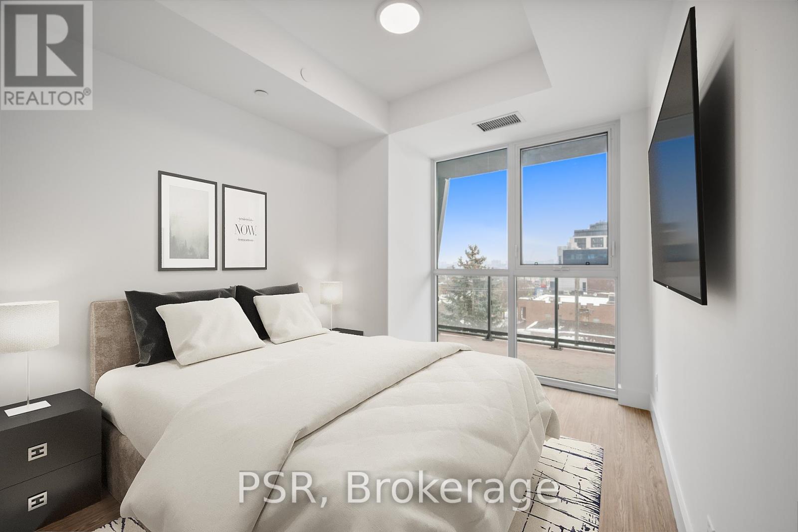 A bedroom with a large bed and a flat screen TV mounted on the wall.
