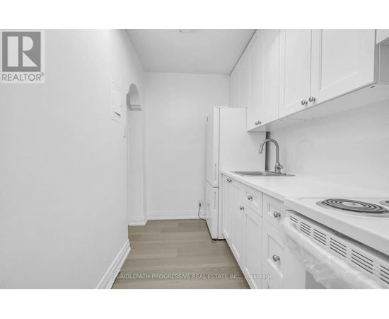 A white kitchen with a sink and cabinets.