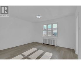 A room with a window and a radiator on the floor.