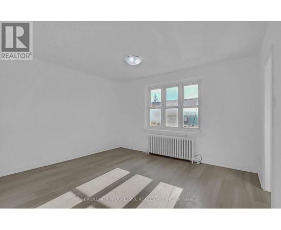 A room with a window and a radiator on the floor.