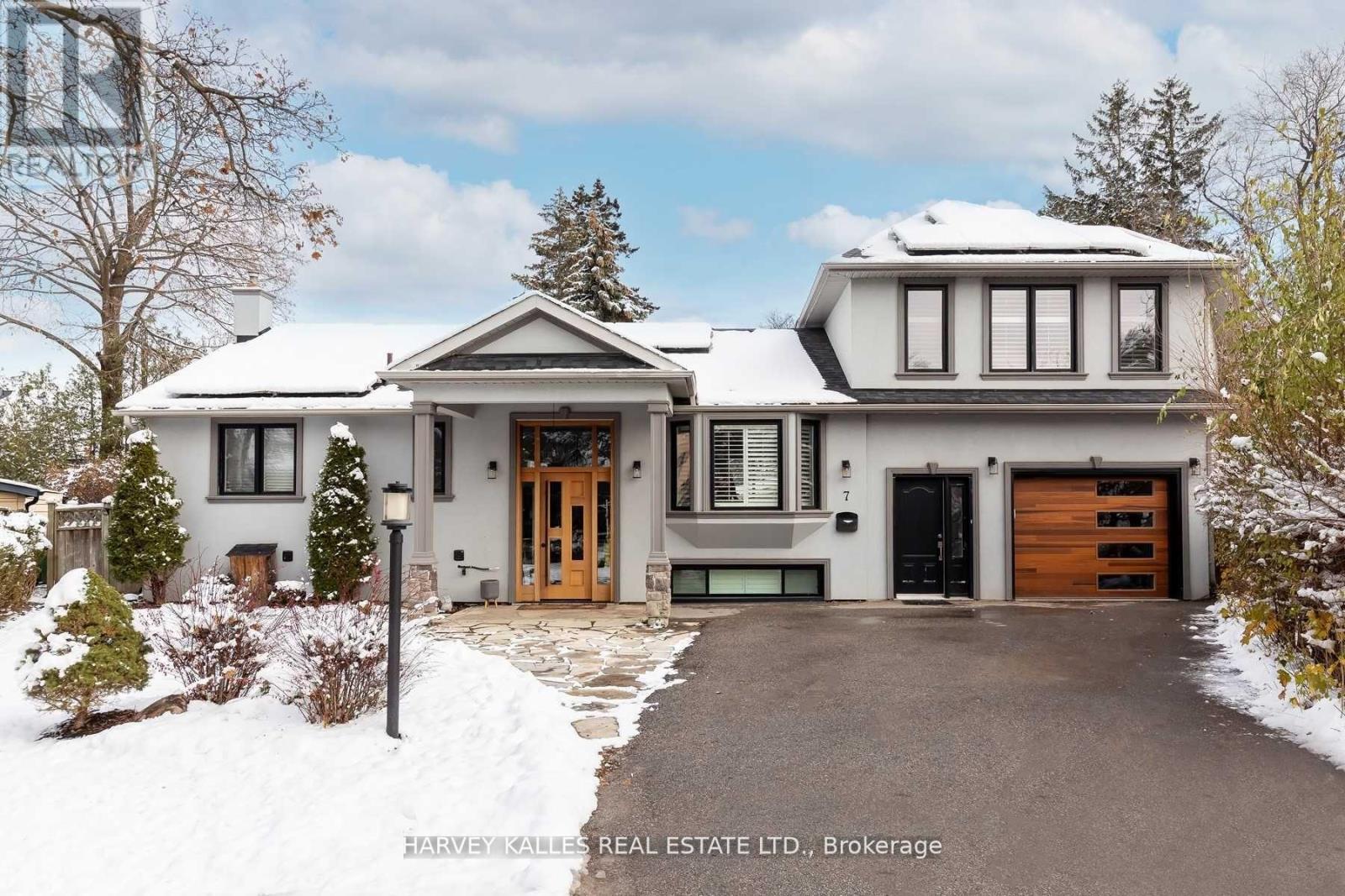 A large, two-story house with a snow-covered front yard.