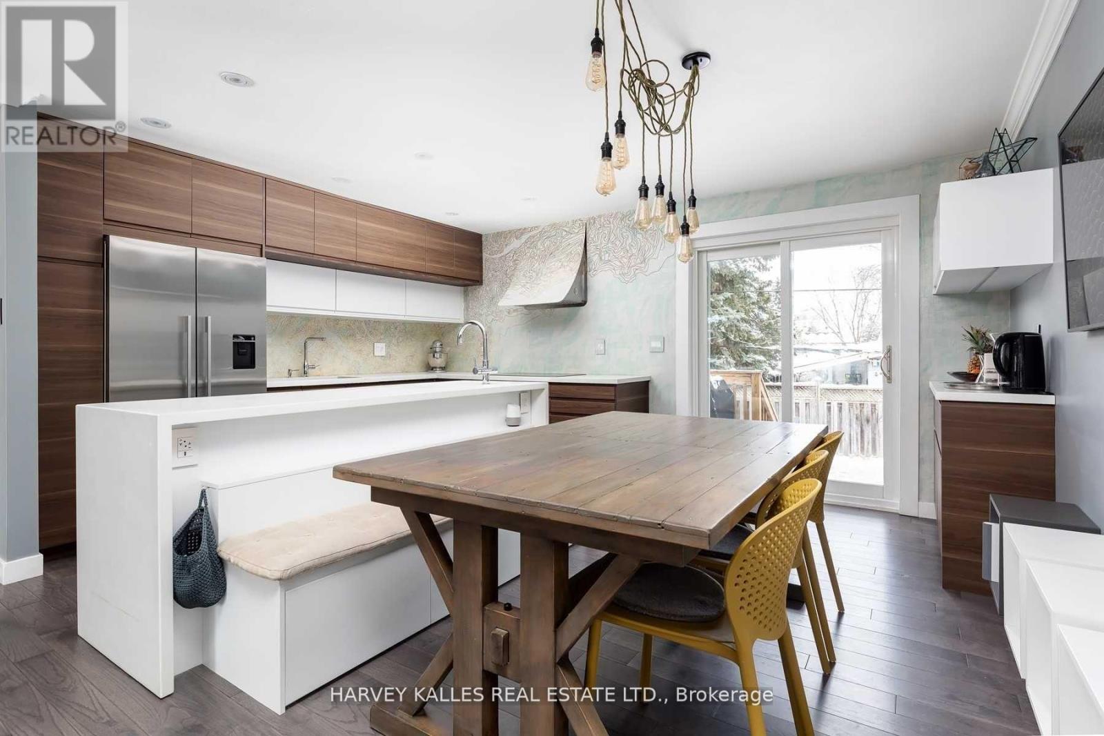 A modern kitchen with a wooden table and chairs.