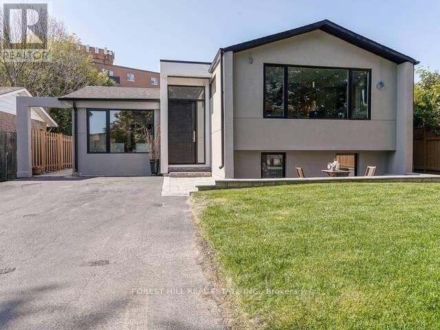 A modern house with a grey exterior and a black roof.