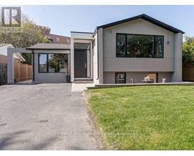 A modern house with a grey exterior and a black roof.