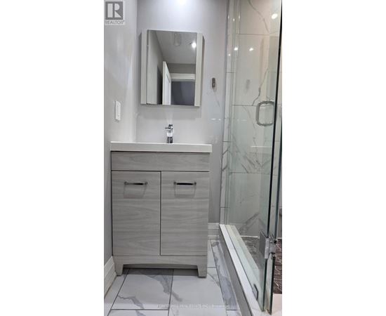 A bathroom with a sink, mirror, and cabinets.