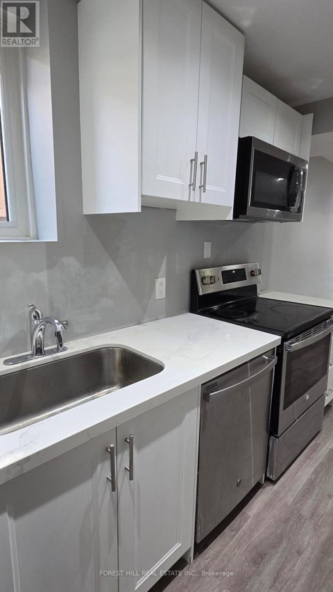 A kitchen with white cabinets and a black countertop.
