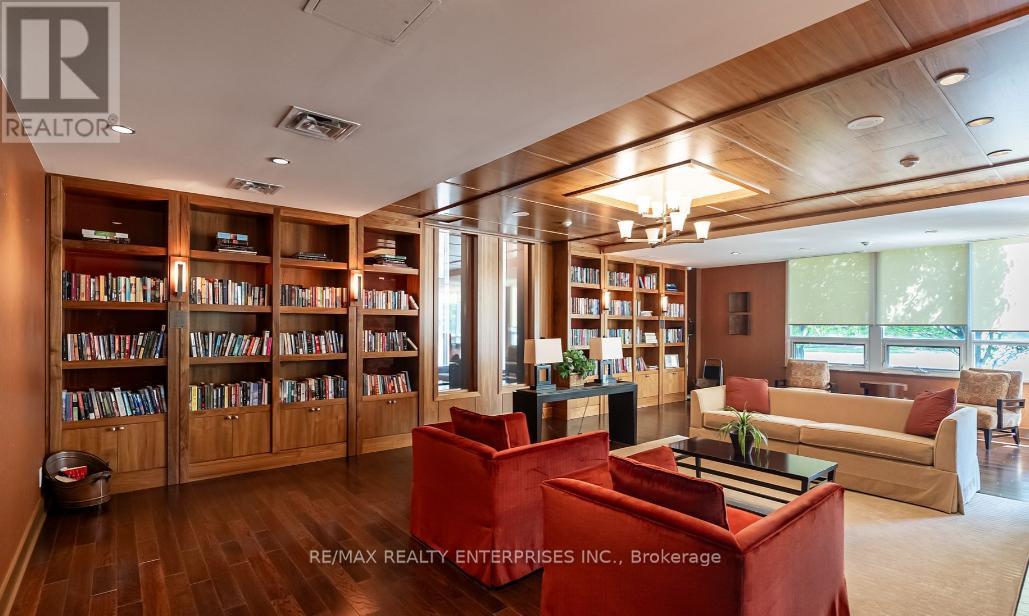 A living room with a bookshelf and a red chair.