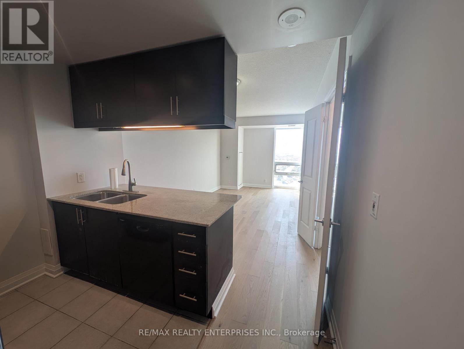 A kitchen with black cabinets and a sink.