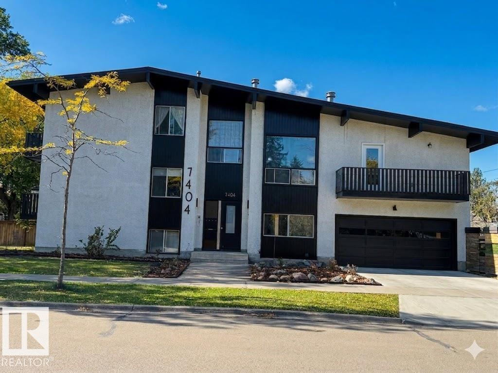 A modern two-story house with a garage and a balcony on the second floor.