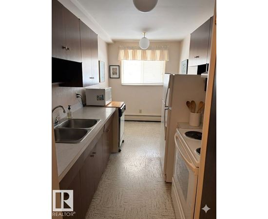 A kitchen with a sink, stove, and refrigerator.