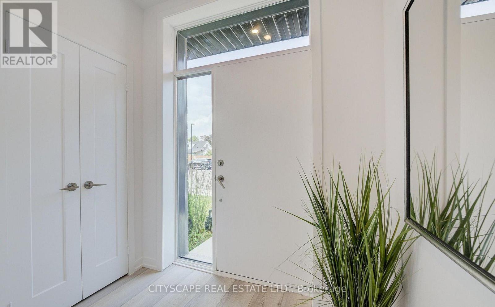 A realtor logo is on the wall in a white room.
