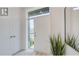 A realtor logo is on the wall in a white room.