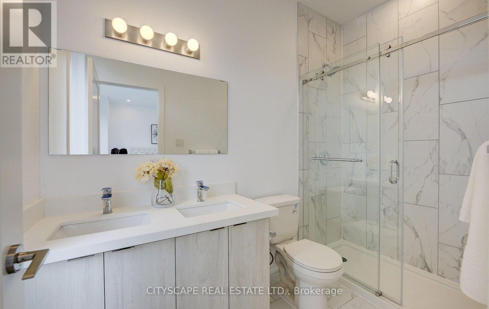 A bathroom with a white sink and a toilet.