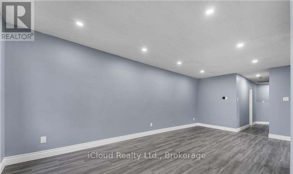 A spacious room with grey walls and wooden flooring.