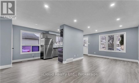 A modern kitchen with stainless steel appliances and a refrigerator with a water dispenser.