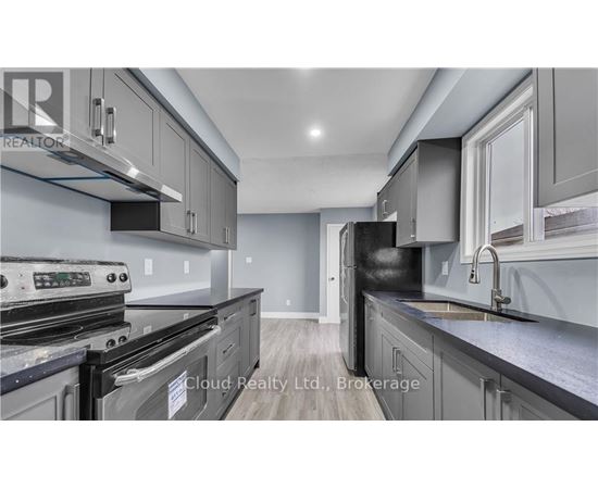 A modern kitchen with stainless steel appliances and grey cabinets.