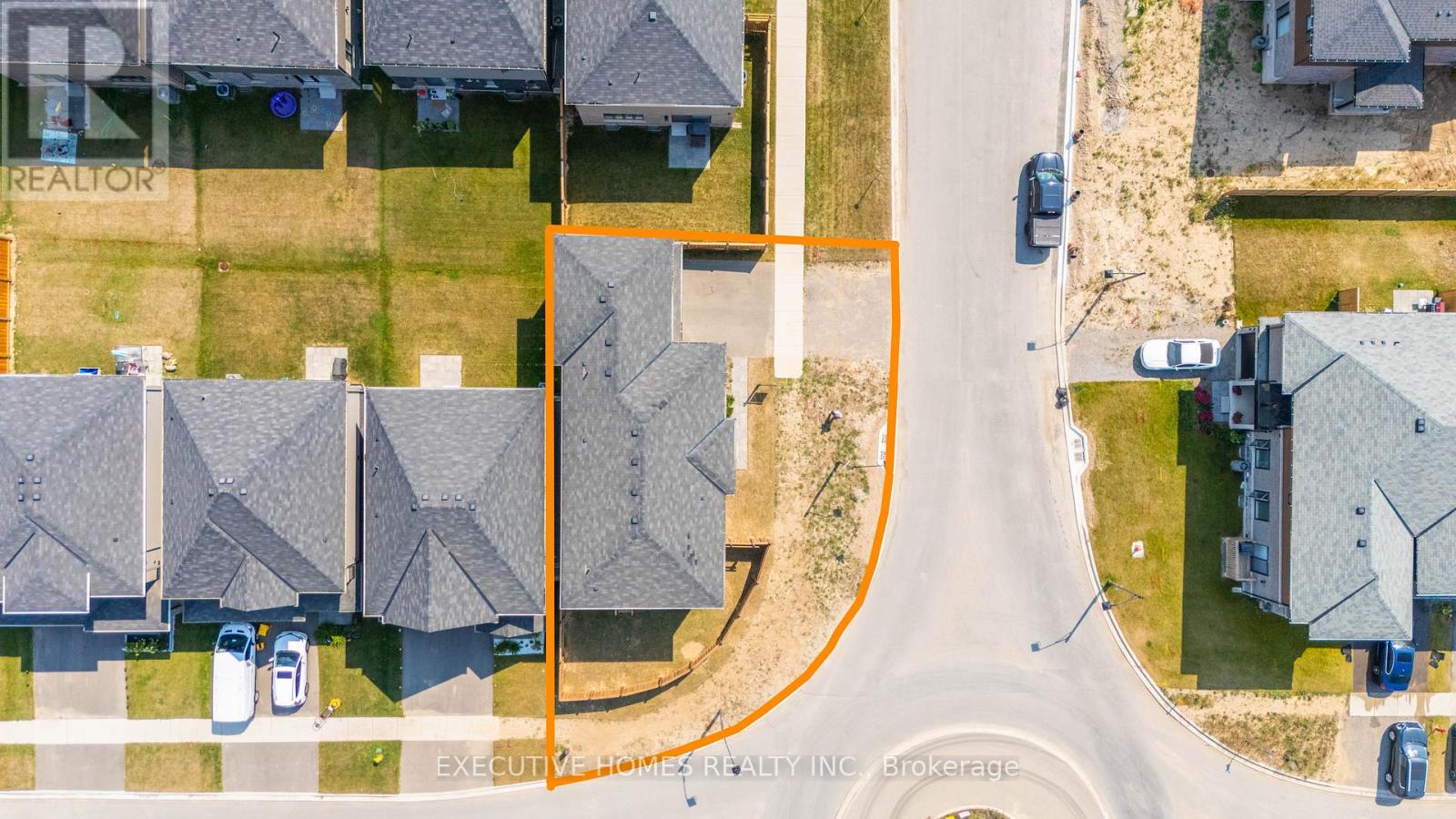 A street view of a residential area with houses and parked cars.