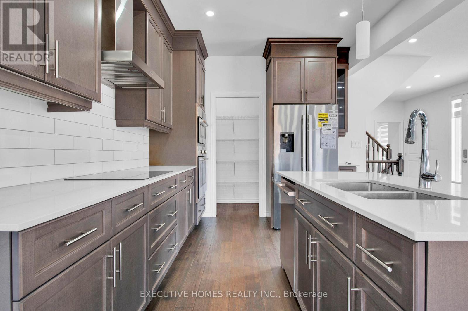 A modern kitchen with dark wood cabinets and white countertops.