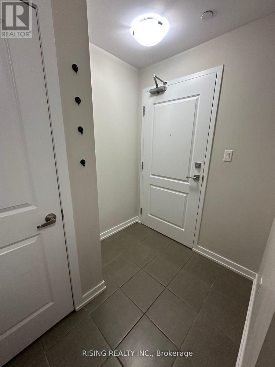 A hallway with a white door and a white door with a peephole.