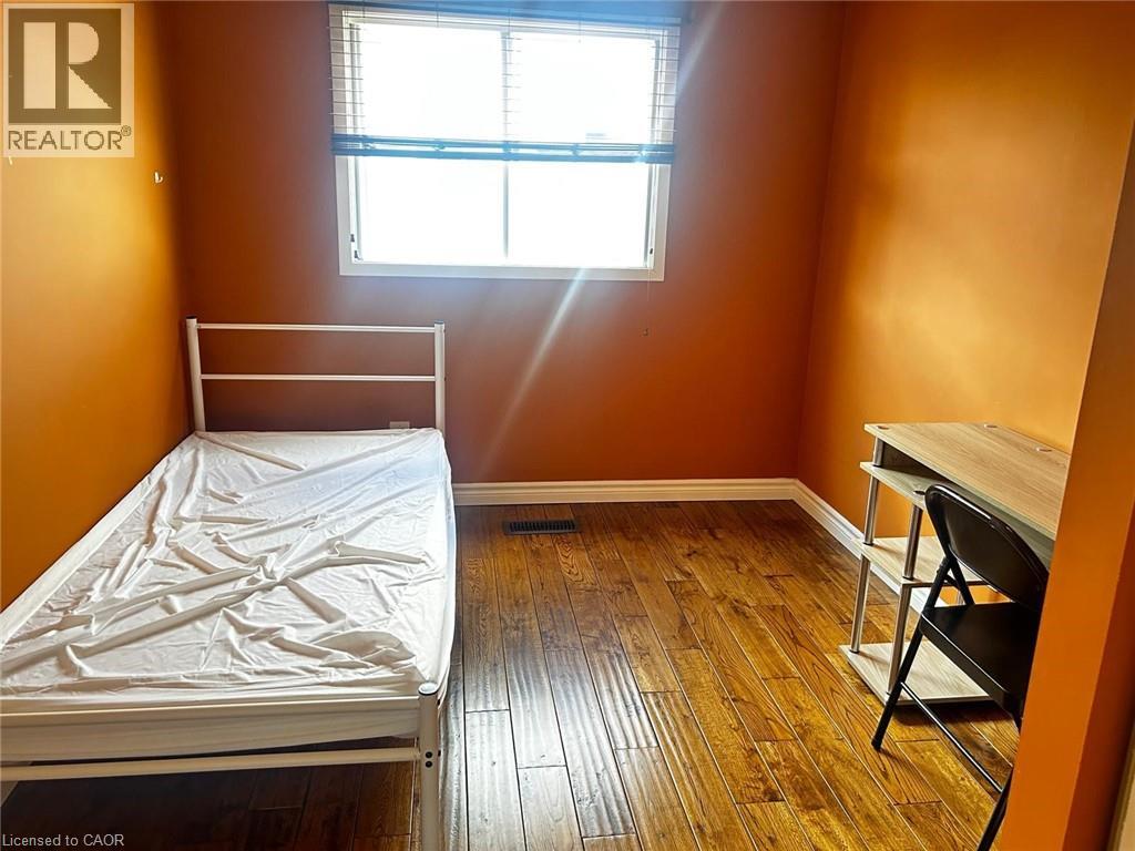 A bedroom with a bed, desk, and chair.