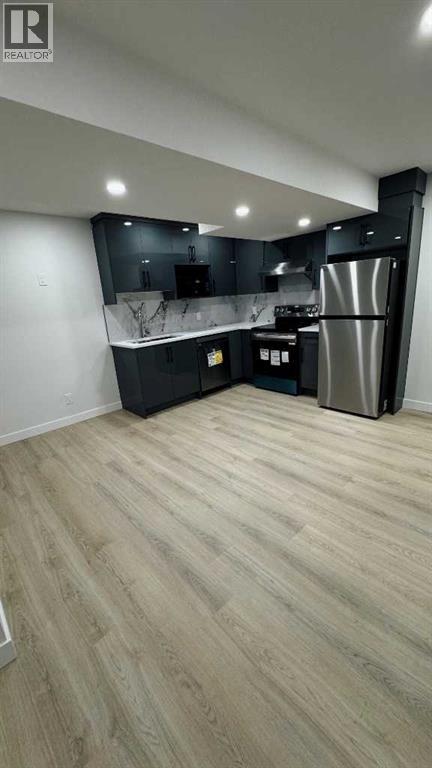 A kitchen with a refrigerator, stove, and sink.