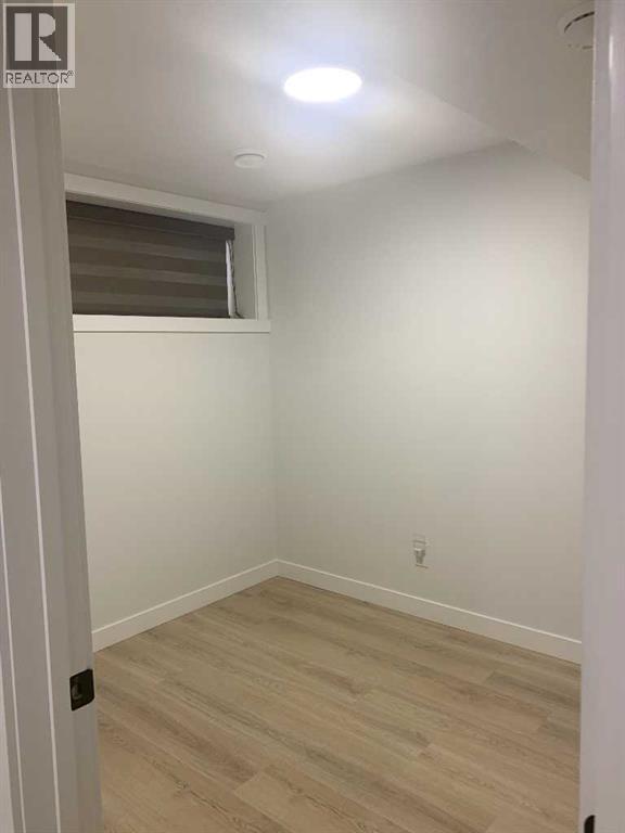 A room with a window and wooden flooring.