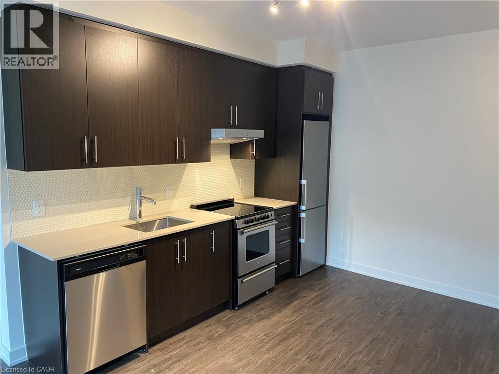 A modern kitchen with dark wood cabinets and stainless steel appliances.