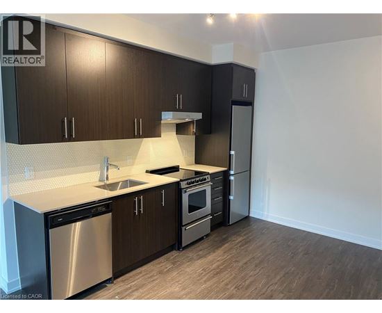 A modern kitchen with dark wood cabinets and stainless steel appliances.