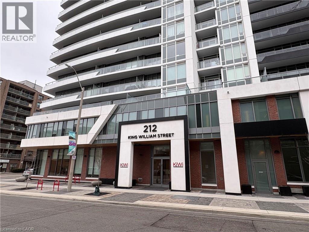 A building with the number 212 on it is in front of a taller building.