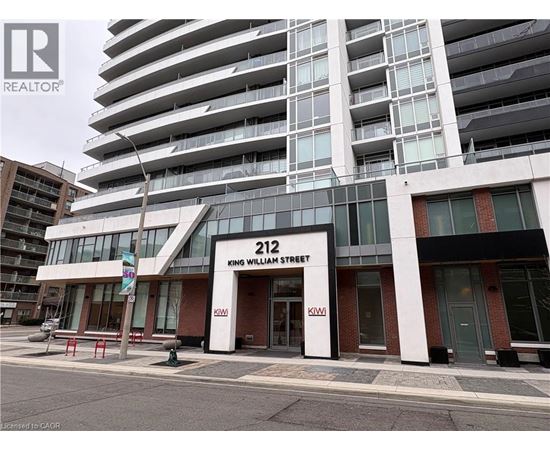 A building with the number 212 on it is in front of a taller building.