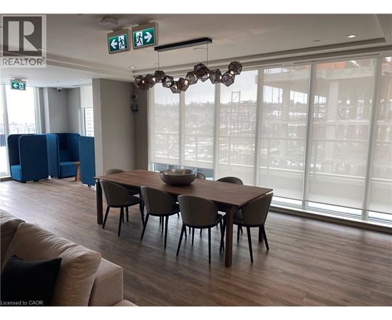 A conference room with a long table and chairs, a couch, and a chandelier.