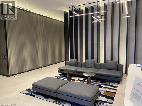 A modern living room with a grey sofa and a glass partition.