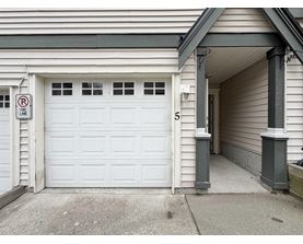 A white garage door with a no parking sign on the wall.