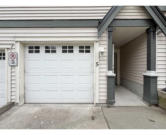 A white garage door with a no parking sign on the wall.