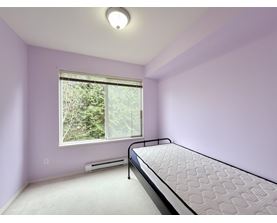 A bedroom with a bed, window, and air conditioner.