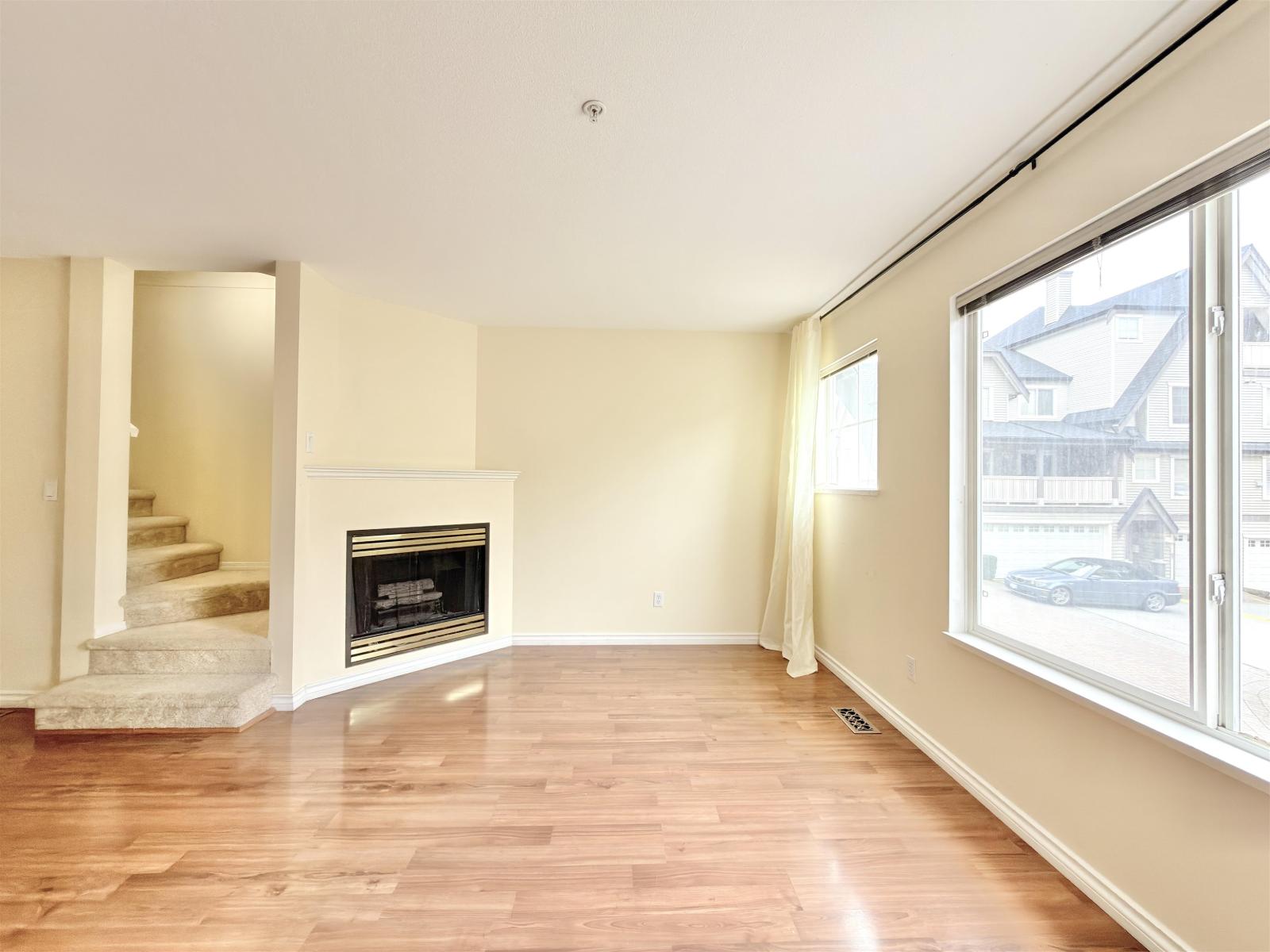 A living room with a fireplace and a staircase.