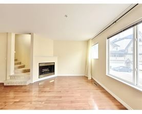 A living room with a fireplace and a staircase.
