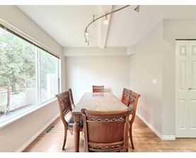 A dining room with a table and chairs.